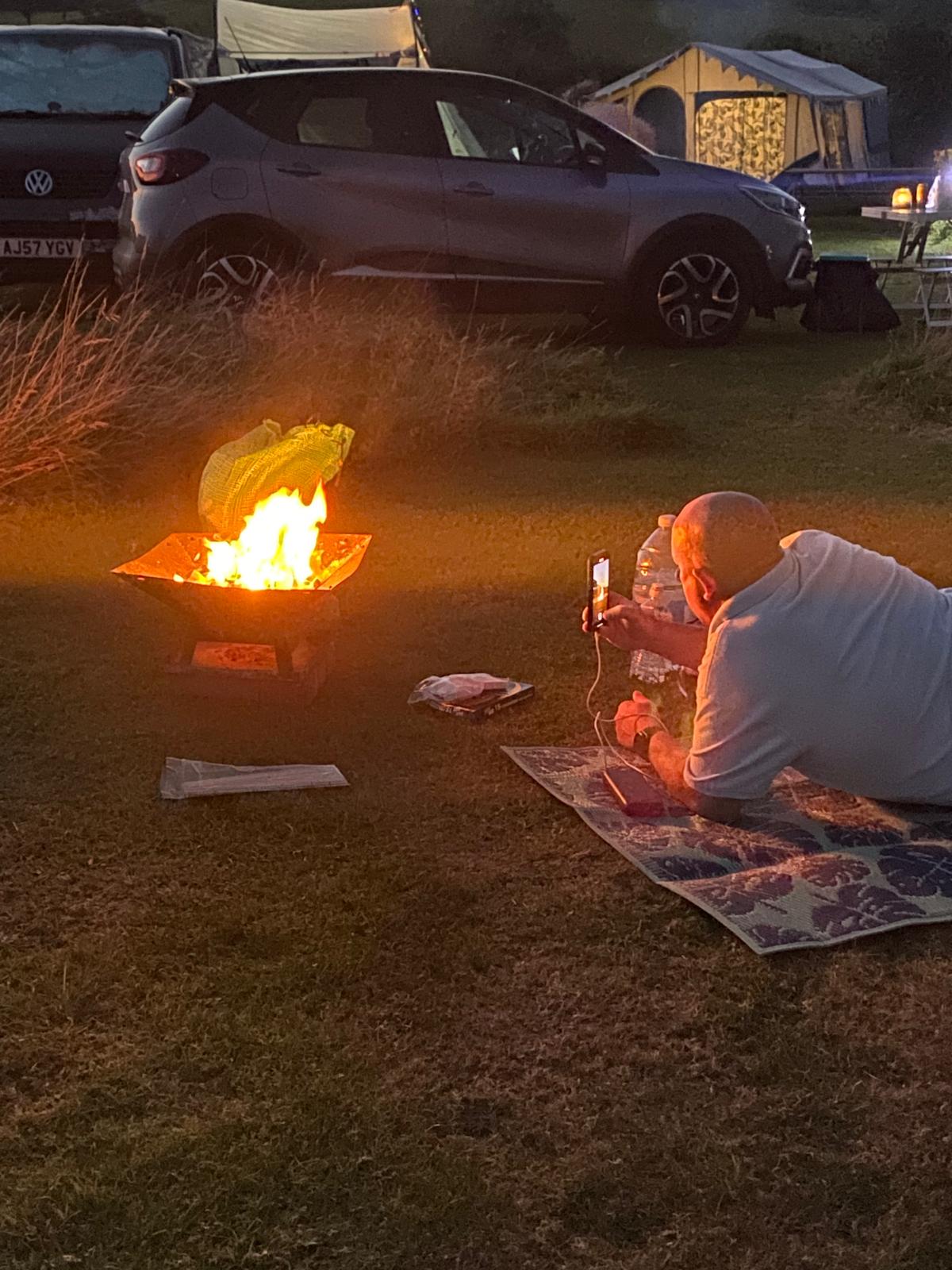 a calper chilling next to a bright warm fire pit