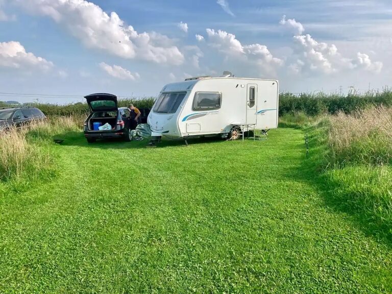 A touting caravan and car on a spacious fully serviced pitch