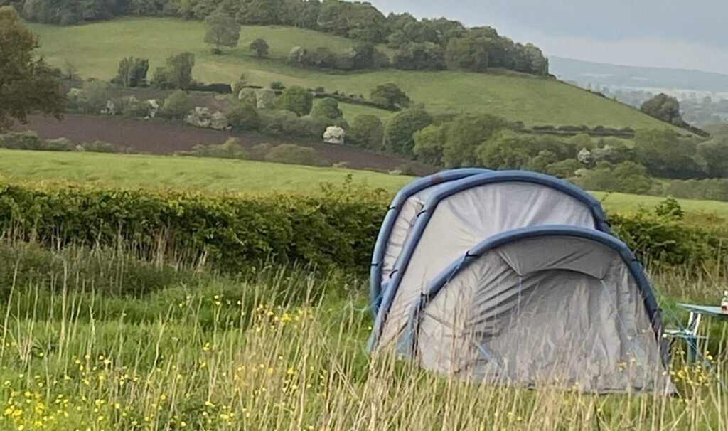 Tent in long grass overlooking the Staffordshire Moorlands