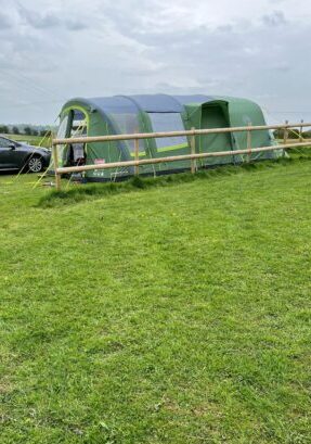 A large green tent on a non electric pitch