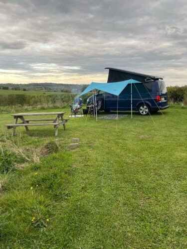 Campervan with a canopy, Camping setup on a fully serviced pitch