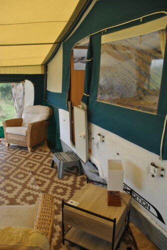 Inside the awning view internal door, side table with lamp and usb ports, single cane chair