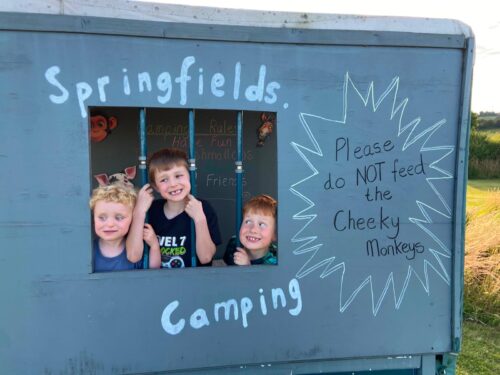 3 children are playing in the converted trailer on the play area